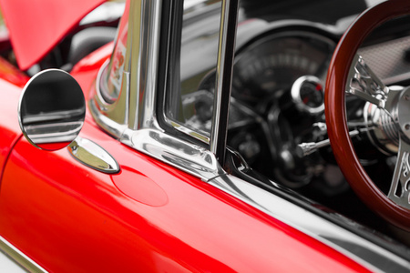 一辆红色的老式汽车的后视镜