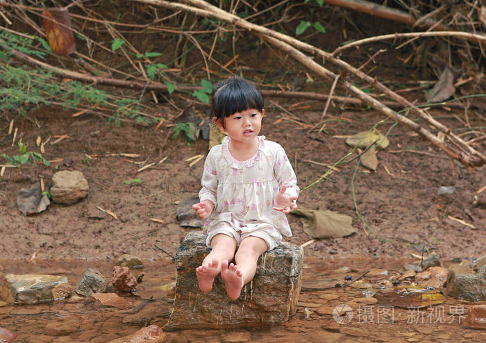 小女孩坐在石头上,玩水,农村泰国照片-正版商用图片0pkzvz-摄图新视界