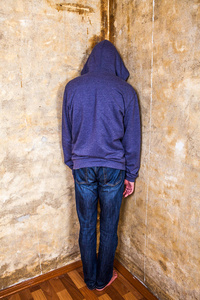 墙角落在旧墙角落的一个男人的后方视图照片