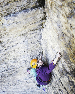 人攀岩者攀岩者爬上岩石墙。男人做硬的移动