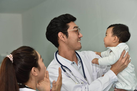 接受治疗的医生和儿童。孩子们在医院接受疫苗接种。小男孩玩红心玩具。和微笑的医院疫苗接种