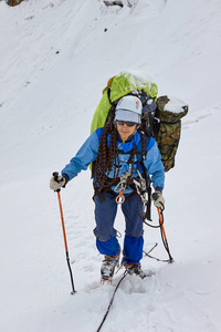 在高山上背包的微笑登山运动员的肖像