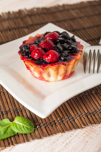 新鲜的浆果挞或蛋糕充满蛋羹，覆盆子，蓝莓醋栗和黑莓的美味甜点，简单的饮食。关闭