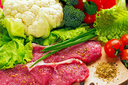 原油成堆的肉牛肉及蔬菜和绿色食品照片