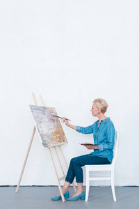 高级女画家在车间刷画照片