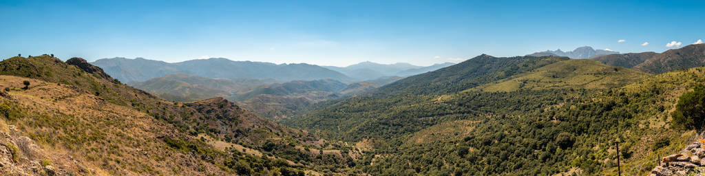 在 Olmi清唱附近的 Balagne 地区的丘陵和山脉的全景视野, 在一个清晰的蓝天与蒙特卡洛 Padru 在距离