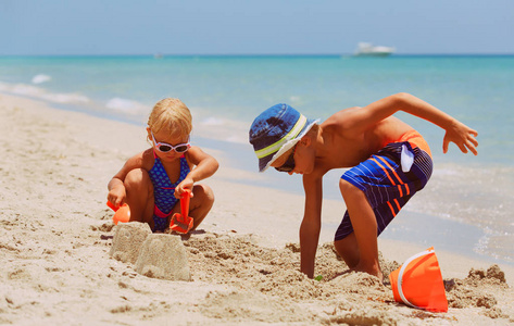 孩子们在夏天的海滩上玩沙子
