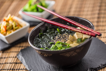 传统日本汤酱配豆腐海带筷子和小洋葱