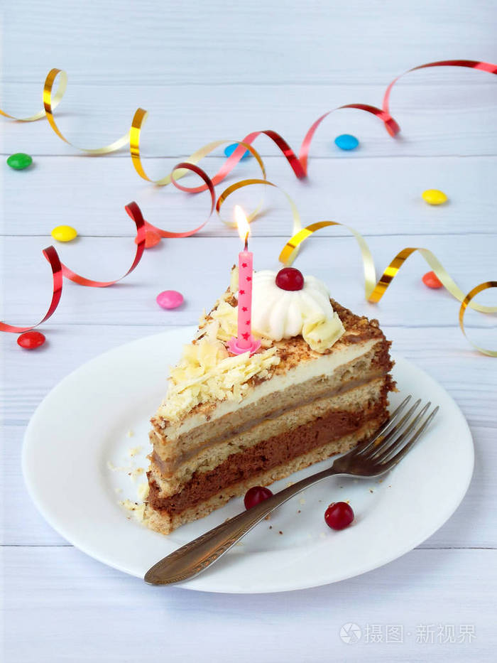 一块巧克力香蕉蛋糕装饰着莲座丛的奶油浆果和轻木背景上的蜡烛生日