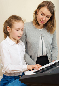 教学小女孩弹钢琴的女人