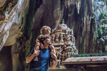 父亲和儿子在巴里洞穴的背景下, 靠近吉隆坡, 马来西亚。儿童旅游概念