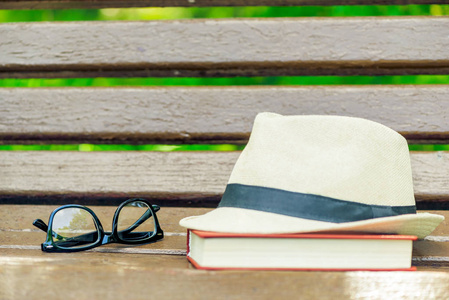 草帽, 眼镜和厚书在标准的木凳上