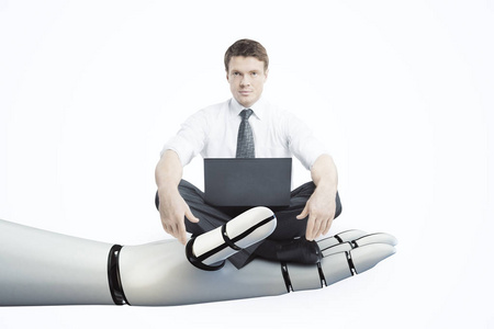 机器人手控股商人与白色背景上的笔记本电脑。机器人技术概念