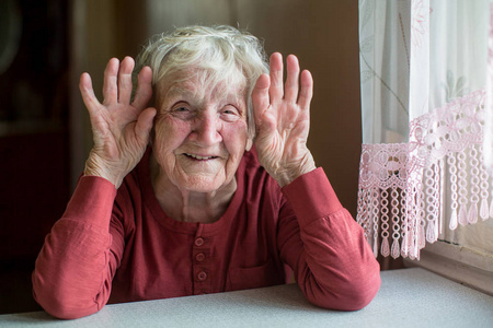 一个老妇人的肖像与亲切的面孔嬉戏照片