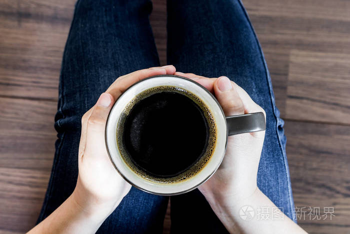 拿着一杯热咖啡的女人的手