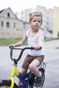 在一辆自行车在沥青路面上的孩子。童年。运动。骑自行车