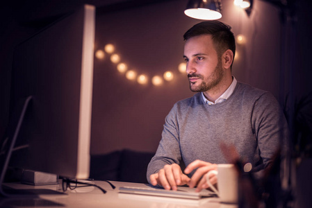 晚上在家办公的年轻人在电脑上工作照片