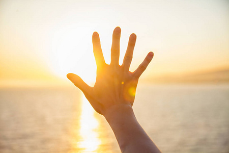 伸向太阳女孩手伸向海面上的太阳照片