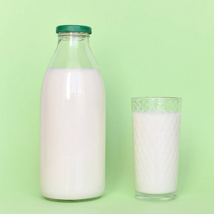 玻璃瓶中的牛奶和带有稻草的透明玻璃杯