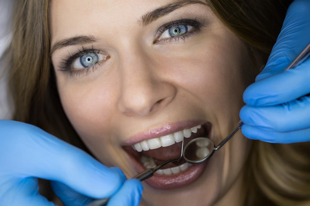 牙医检查病人牙齿的牙医