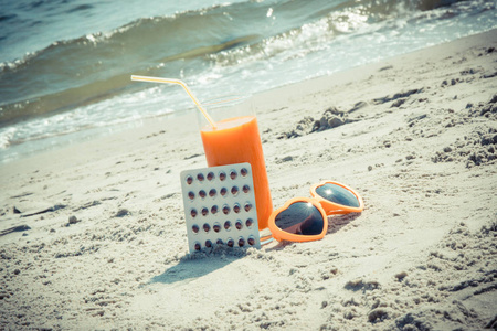 老式照片 服药 胡萝卜汁和太阳镜在海滩 预防维生素 A 缺乏症，美丽和持久谭的概念