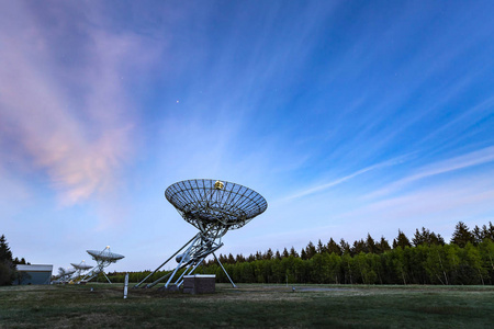 Westerbork 合成射电望远镜 Wsrt 在黄昏时分, 有一盏淡多云的天空和一点可见的星星。由14天线的线性阵列组成的