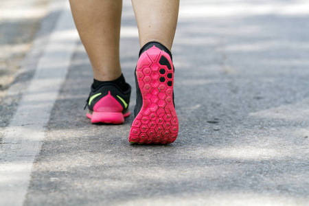 运动员赛跑者脚上道路特写鞋上运行。女人健康