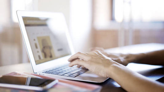 女性白色手上的铝笔记本电脑键盘打字短信