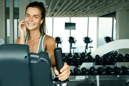 运动中的女人听音乐在健身房锻炼