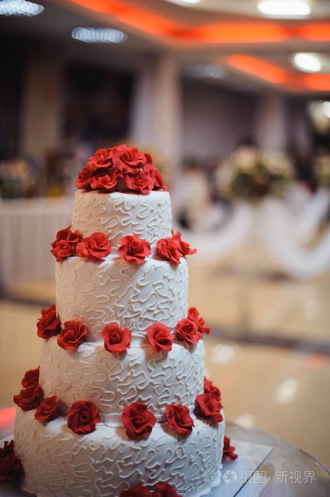 白色婚礼蛋糕装饰红红花朵上的婚礼