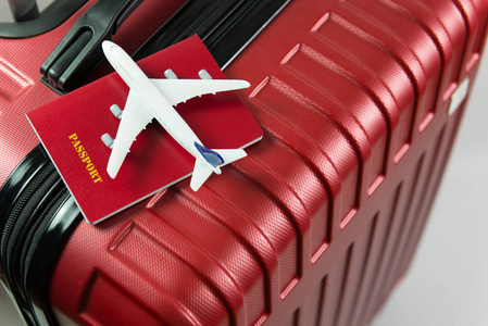 红色护照和飞机模型在红色行李