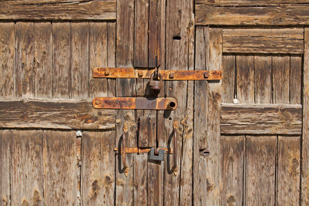 旧棕色木质门与生锈的句柄和锁