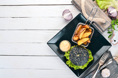 黑汉堡配肉, 洋葱和生菜。在一个木质的背景。顶部视图。复制空间