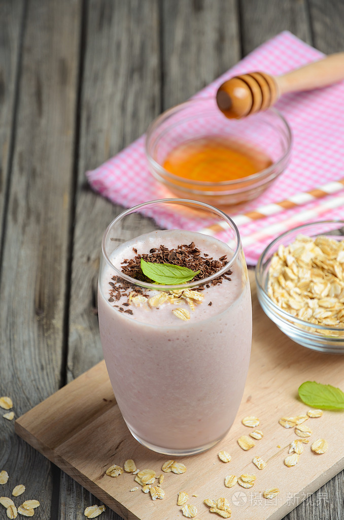 草莓和香蕉奶昔燕麦片仿古木制的桌子上