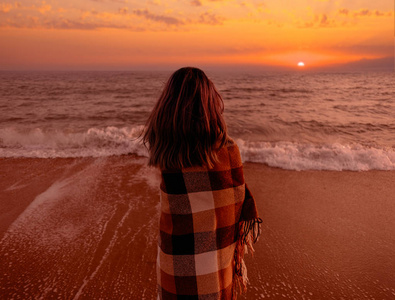 日落时分女子站在沙滩上