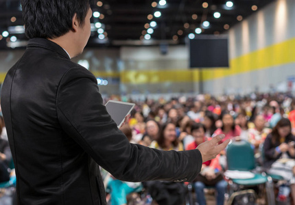 商业人士会议的后视图在会议大厅或研讨室的模糊的相片在阶段与与会者