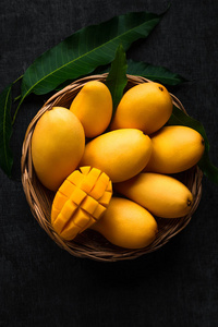 黄色芒果美丽的皮肤在篮子黑板背景