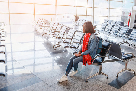 女游客带着背包在机场休息室等她的航班