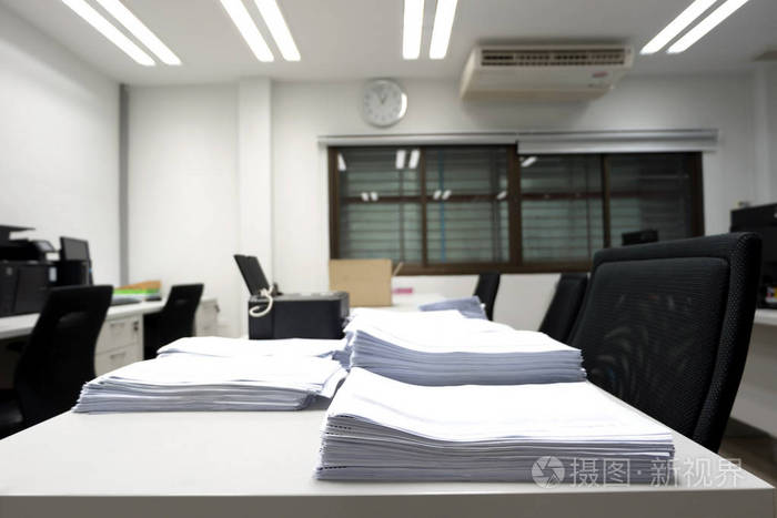 软的集中在未完成的文件和打印机放置在办公桌与模糊的空工作办公室