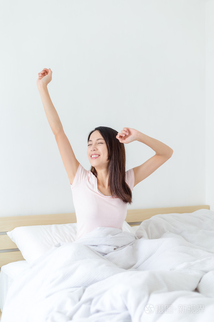 醒来后伸展躺在床上的女人照片-正版商用图片0po3oo-摄图新视界