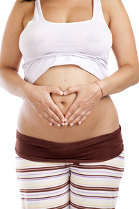 怀孕的女人，在她的肚子被隔绝在白色背景制作心与手的形状