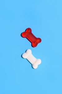 在蓝色的骨头形状的甜红色和白色软糖糖果的顶部视图