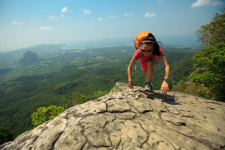 在山顶上攀爬的年轻女子