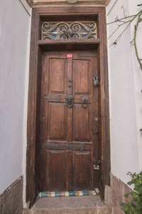 在土耳其 Ayvalik 的历史房子的旧木门和石墙的关闭视图。图片显示爱琴海建筑风格