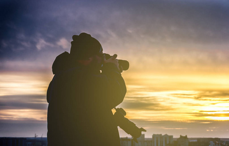 两个摄像头拍摄日落从屋顶的摄影师