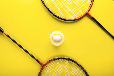 羽毛球和球拍, 在黄色的背景下打排球。极 简 主义。概念夏天 razlecheny