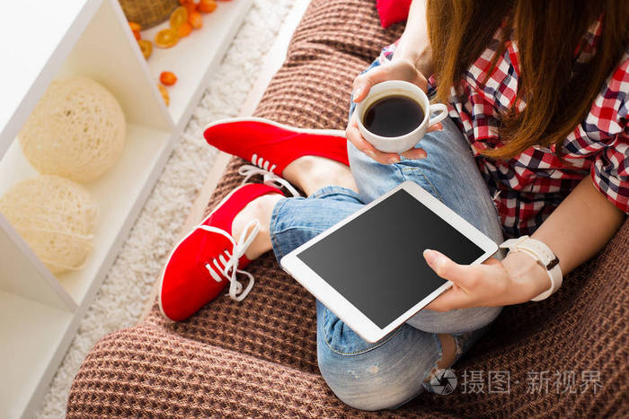 女人在家里放松在沙发沙发上阅读电子邮件在平板电脑wifi连接上