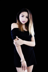 有吸引力的亚裔女子站在黑色的连衣裙