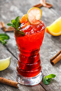 冷新鲜红色柠檬水薄荷 肉桂 橙冰杯木制背景上。夏季饮料和酒精的鸡尾酒