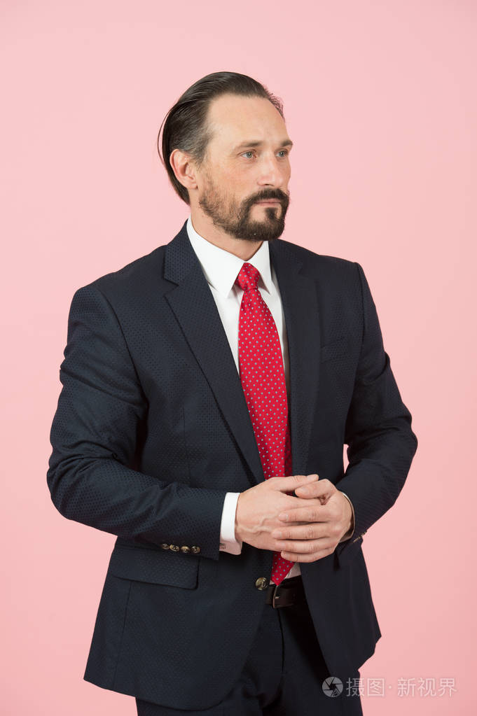 红领带和黑色西装经理画像在粉红色背景下的工作室隔离